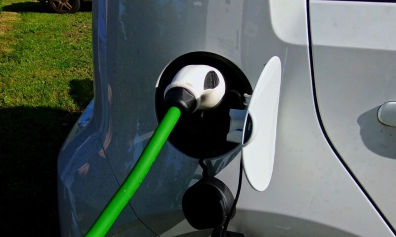 osoba uključuje auto da se puni na električni punjač