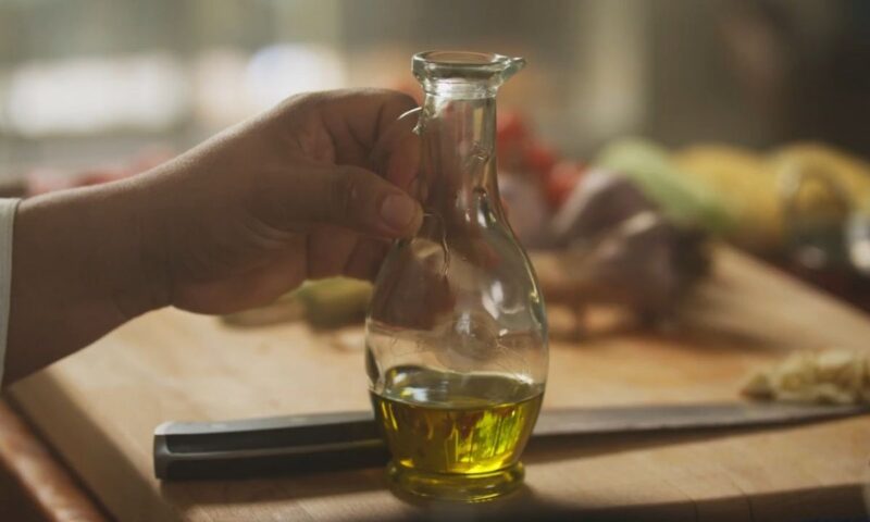 osoba drži staklenu flašu sa amslinovim uljem u ruci