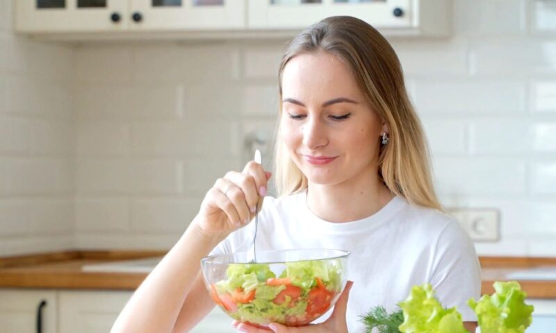 devojka jede salatu iz staklene činije