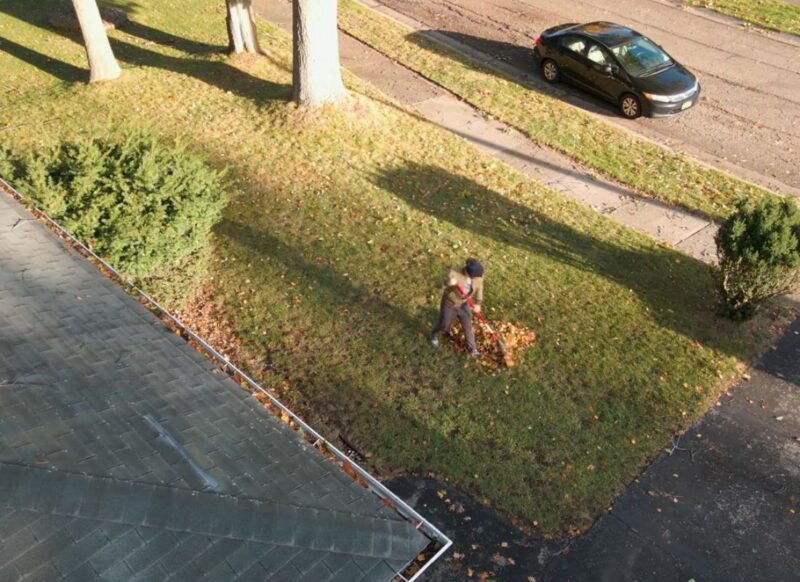 momak skuplja sa grabuljom lišće