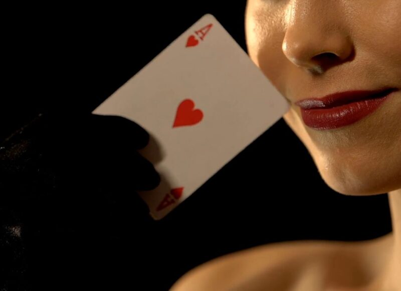 devojka sa karminom na usnama drži kartu u ruci