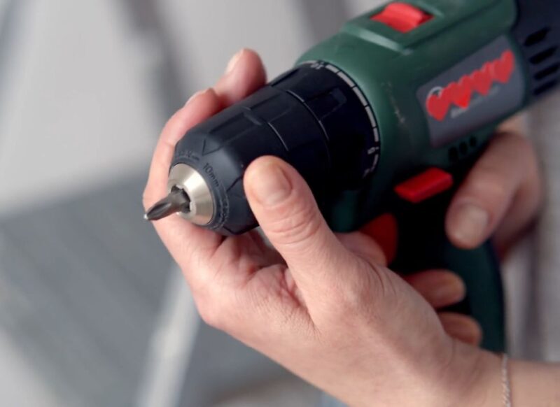 osoba podešava bušilicu