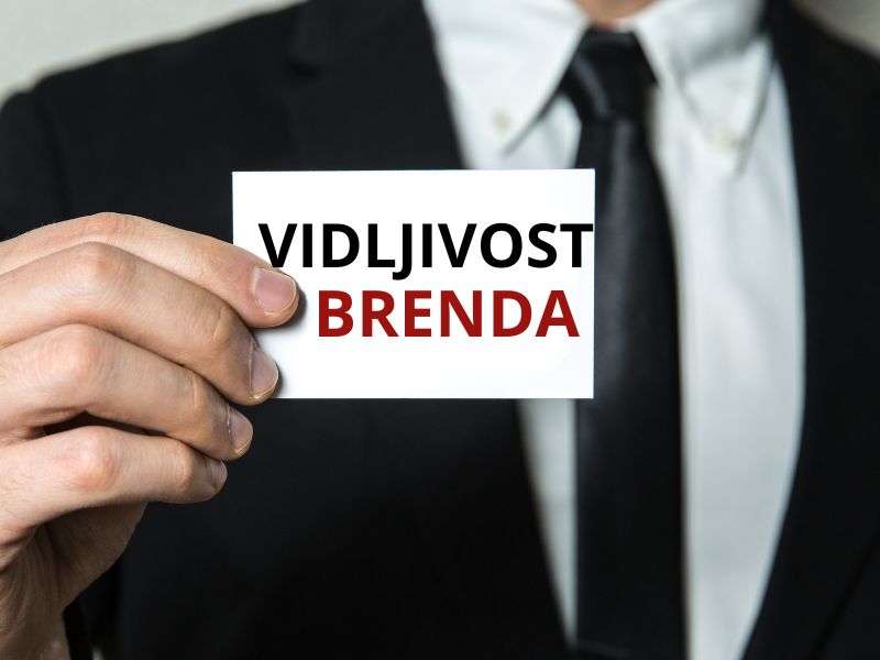 muškarac drži karticu na kojoj piše vidljivost brenda